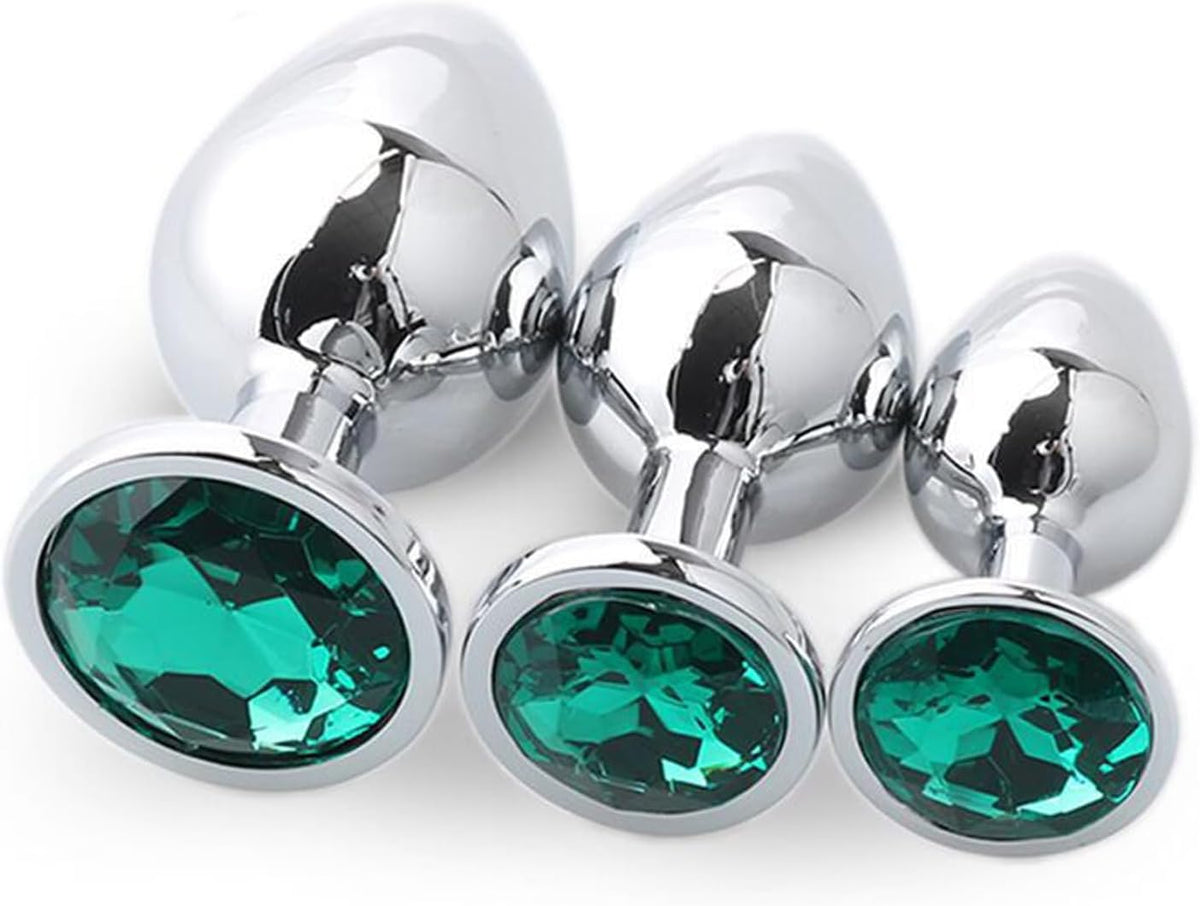 Three metallic silver butt plugs with faceted green gemstone base.